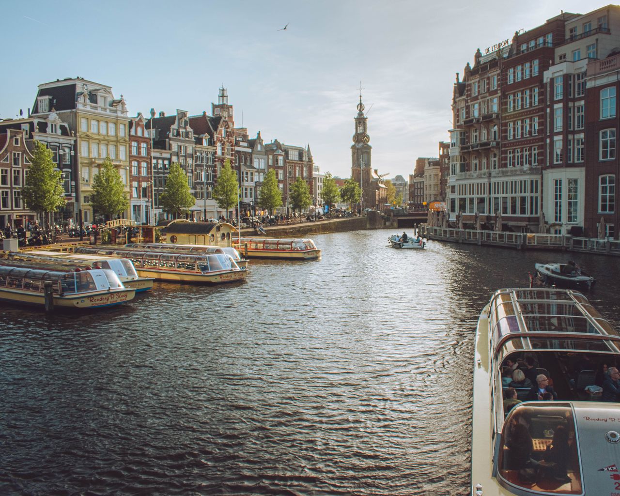 The Art of Drawing Readers In: Your attractive post title goes here Charming view of Amsterdam's canals with tour boats and historic buildings, capturing the essence of the city.